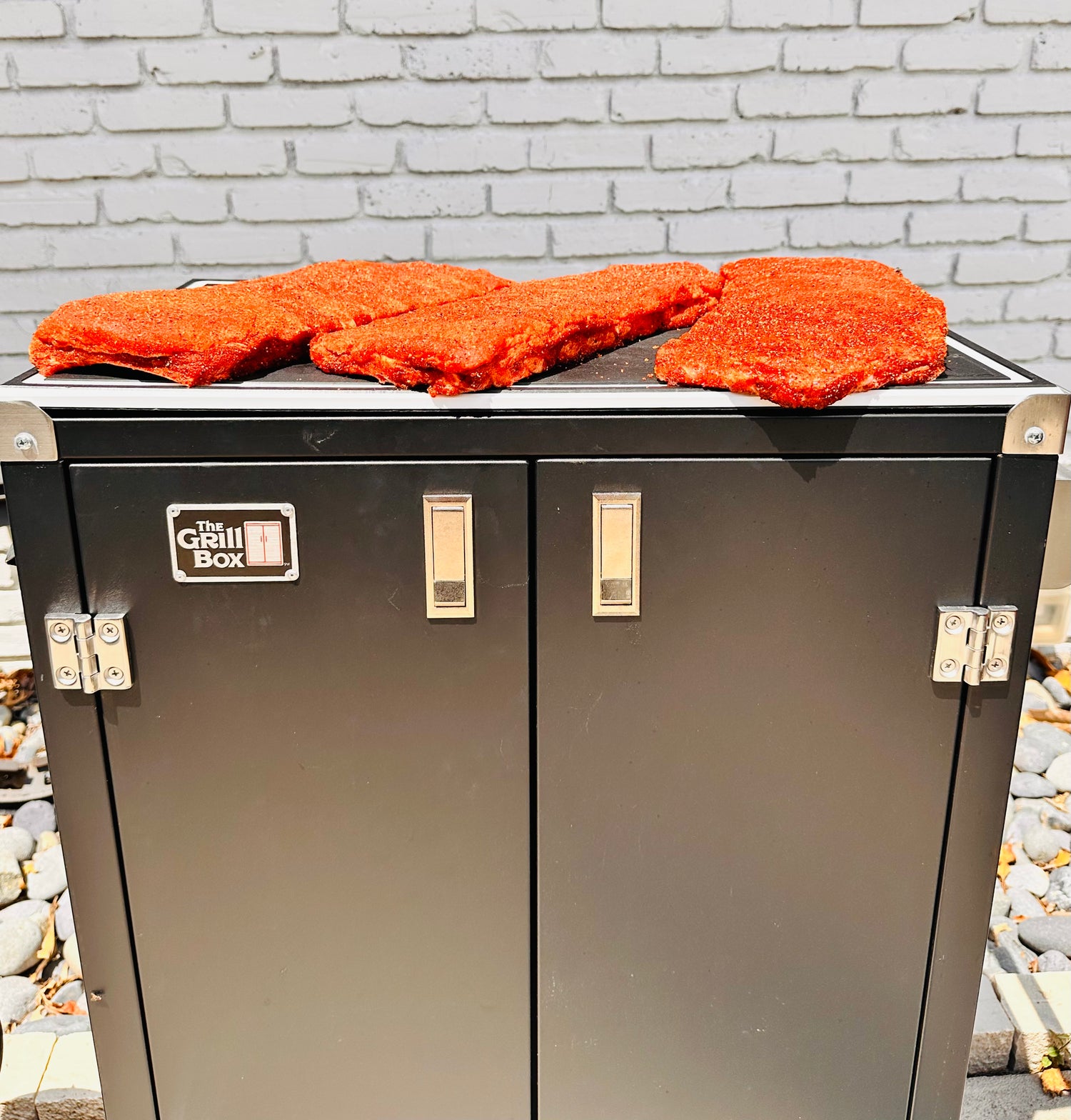 Ribs on a grill box with a brick wall background